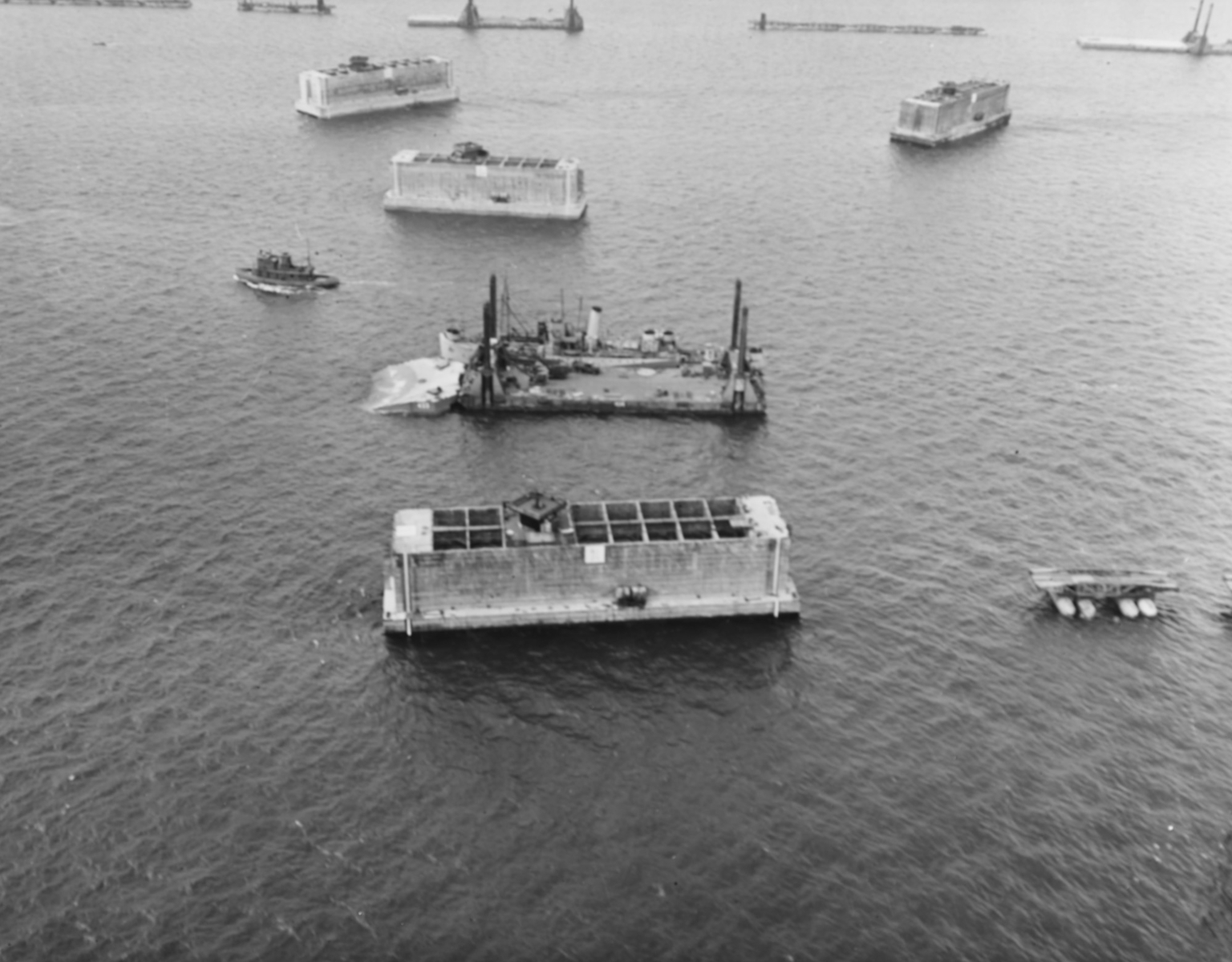 Installation de caissons Phoenix et de routes flottantes au sein d’un port artificiel en Normandie, le 14 juin 1944