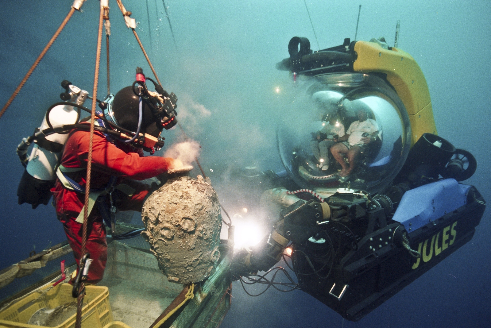 Photographie d'un sous-marin éclairant un plongeur faute de visibilité