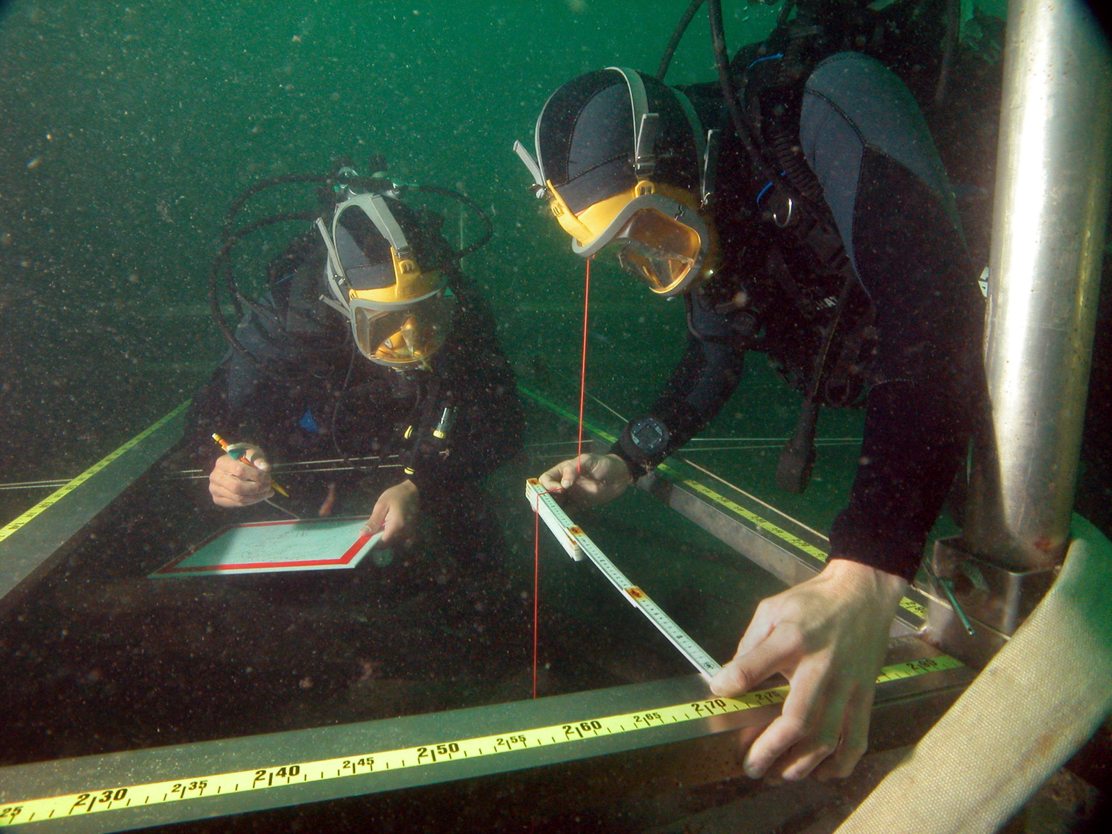 Photographie sous-marine de deux plongeurs prenant des mesures