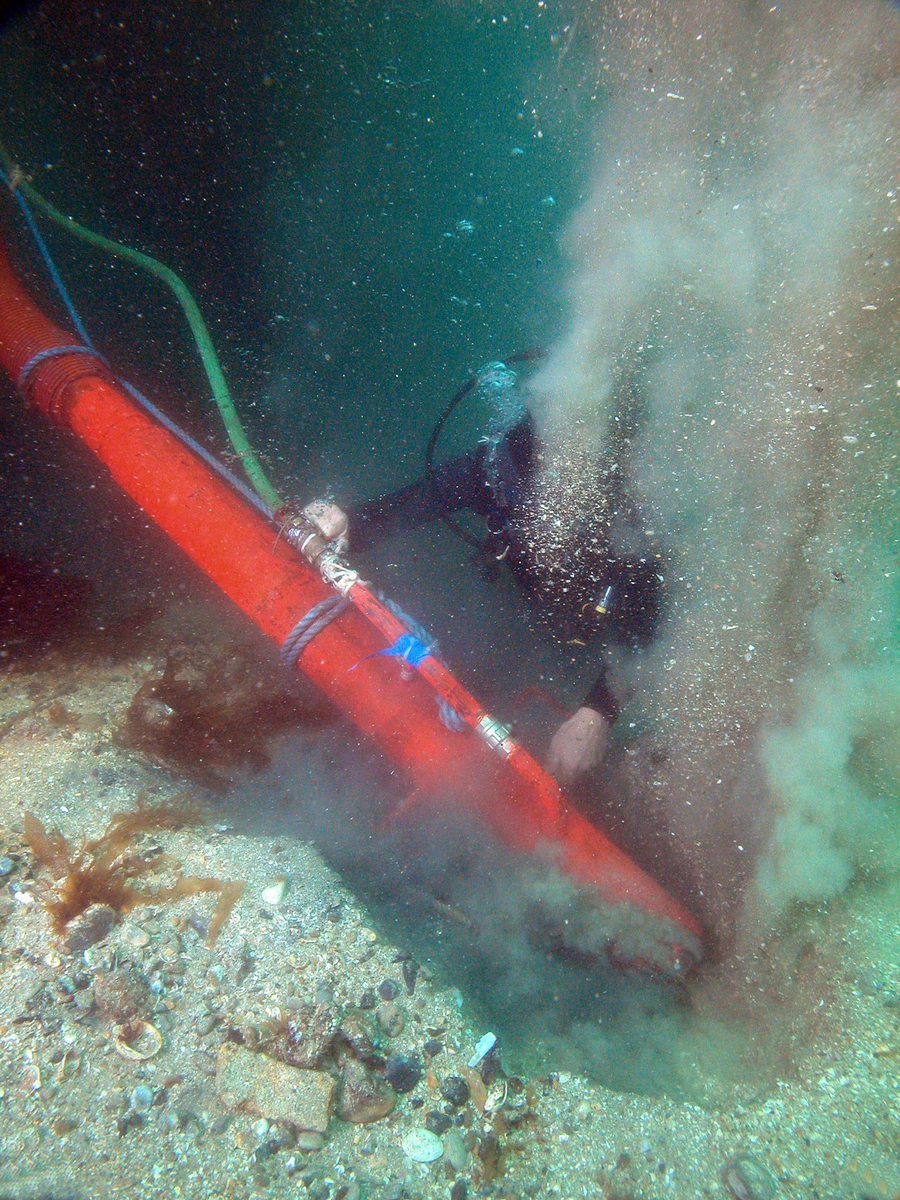 Photographie sous-marine d'un plongeur dégageant les couches superficielles