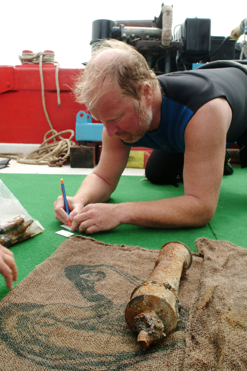 Photographie d'un chercheur étiquetant un clystère en étain