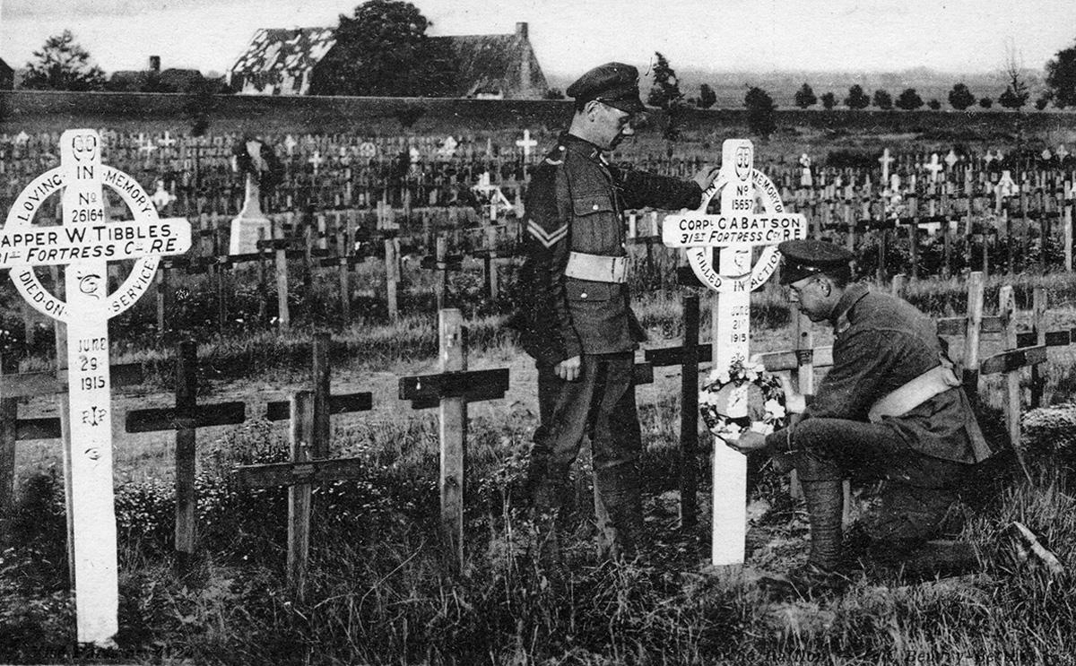 Deux soldats déposant une gerbe de fleurs sur une croix