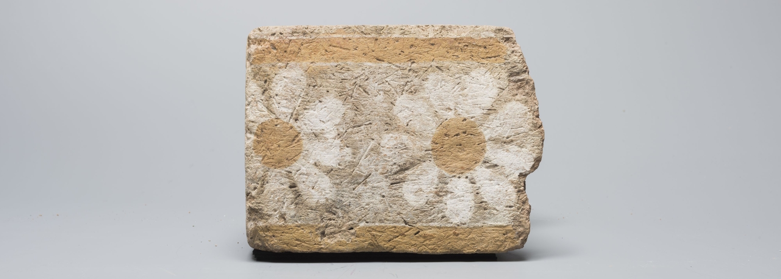 Fragment de brique ornée de rosettes