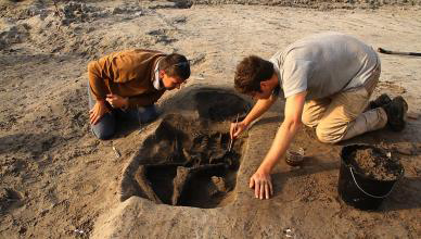 Photographie d'archéologues mettant au jour une sépulture