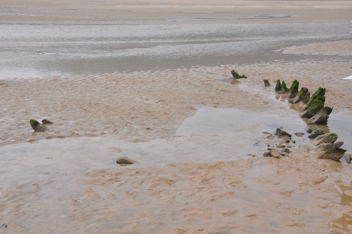 Photographie de l'épave Sables d'Or 3 enfouie sous le sable de l'estran