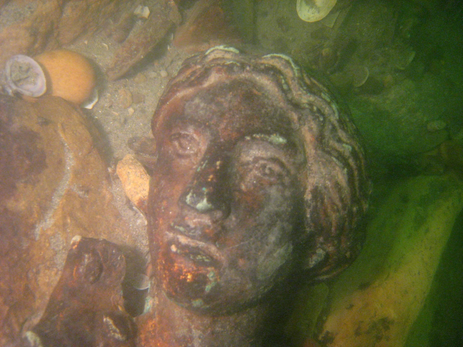 Photographie d'un visage en bas-relief en bronze doré