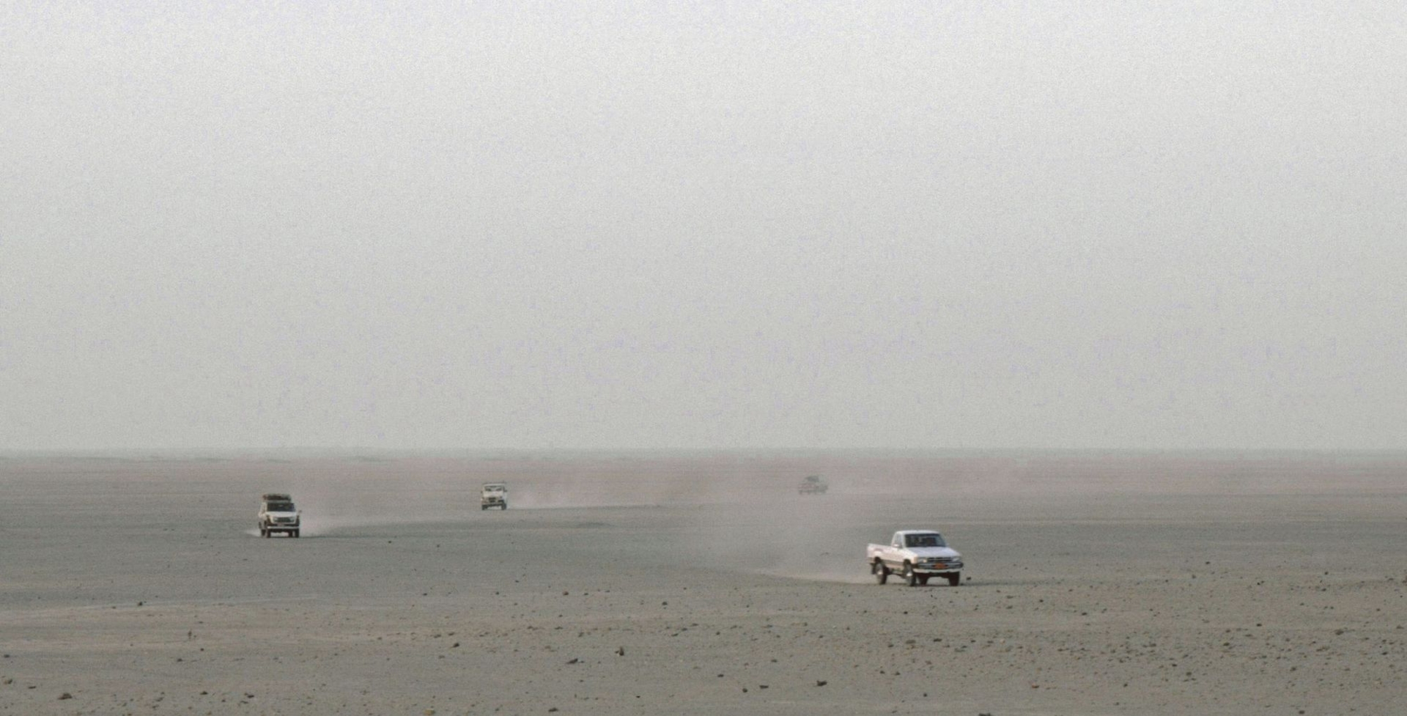 Des voitures au milieu de la plaine mésopotamienne. © Mission Archéologique française de Larsa, cliché Joël Suire