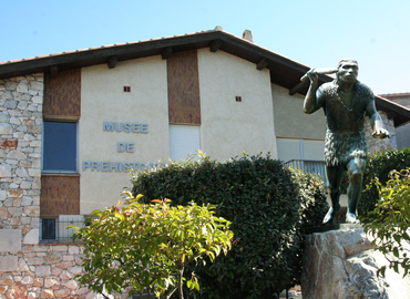 Statue en bronze de l'Homme de Tautavel, du sculpteur Catalan, André Bordes, installée devant l'entrée du Musée de Préhistoire.